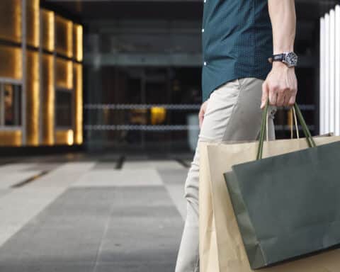 Man's legs and shopping bags outside a luxury mall